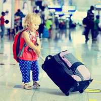 Image of a child pulling a small suitcase at the airport terminal 
